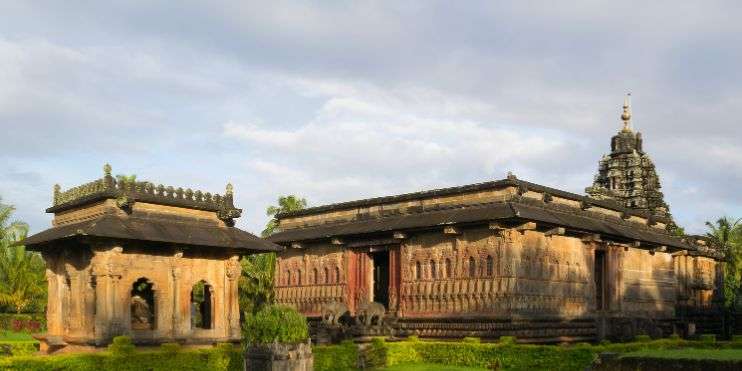 A temple nestled amidst vibrant green grass, creating a serene and picturesque setting.